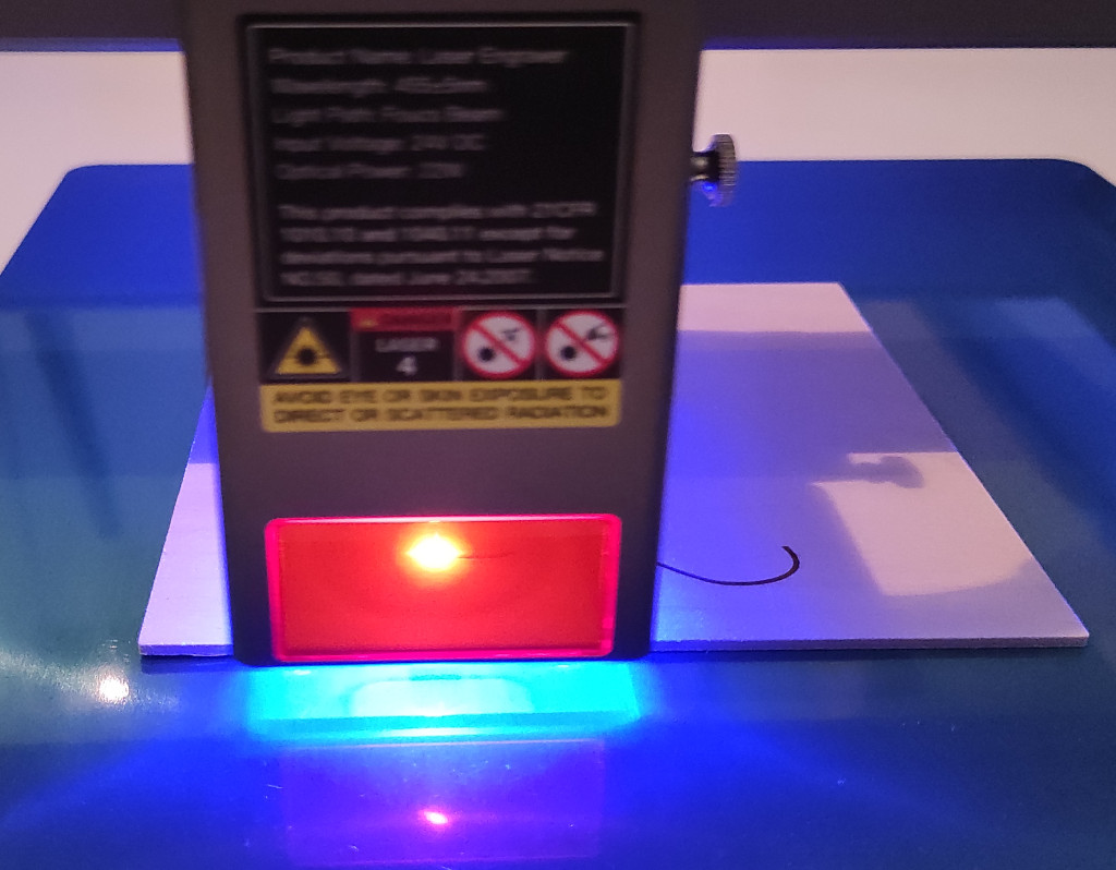 Picture of laser head. Blue laser cutting wood 