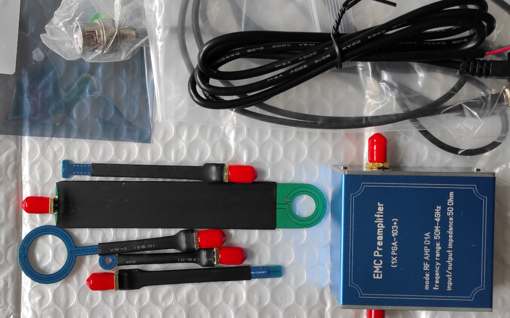 Picture - On the left side there is set of 5 EMC probes, 4 are blue and one is green. On the right side is EMC Preamplifier